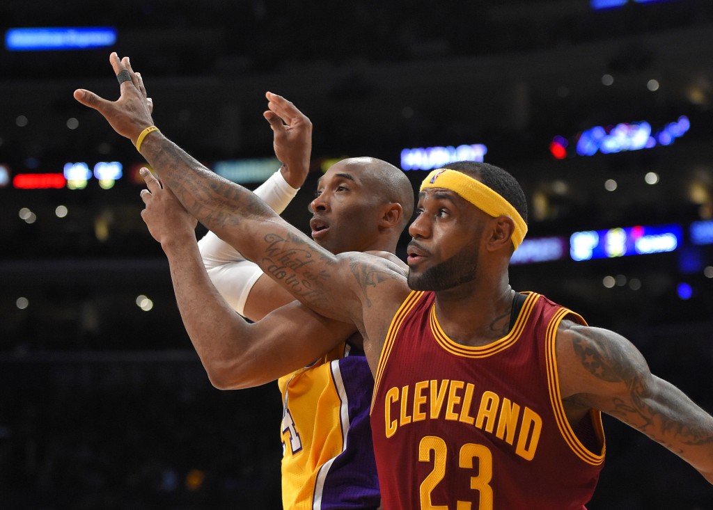 Cleveland Cavaliers forward LeBron James (right) guards Los Angeles Lakers guard Kobe Bryant as Bryant passes the ball during the first half of an NBA basketball game on Thursday in Los Angeles. AP