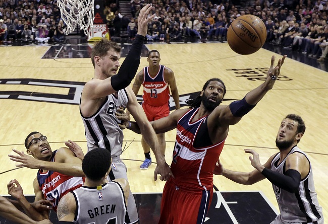 Washington Wizards' Nene (42) reaches for a rebound between San Antonio Spurs defenders Tiago Splitter (22) and Marco Belinelli, right, during the second half of an NBA basketball game, Saturday, Jan. 3, 2015, in San Antonio. San Antonio won 101-92.  AP