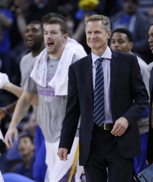 Golden State Warriors coach Steve Kerr smiles during a timeout as his team plays the Dallas Mavericks during the first half of an NBA basketball game Wednesday, Feb. 4, 2015, in Oakland, Calif. (AP Photo/Marcio Jose Sanchez)