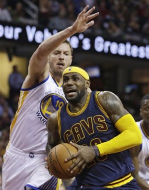 Cleveland Cavaliers' LeBron James, front, drives past Golden State Warriors’ David Lee during the second quarter of an NBA basketball game Thursday in Cleveland. AP Photo