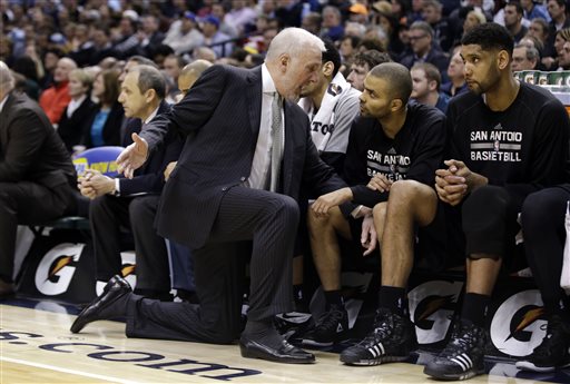 San Antonio Spurs head coach Gregg Popovich talks with Tony Parker as Tim Duncan watches the game during the second half of an NBA basketball game against the Indiana Pacers Monday, Feb. 9, 2015, in Indianapolis. San Antonio won the game 95-93. Popovich reached the 1,000-win milestone Monday night. (AP Photo/Darron Cummings)