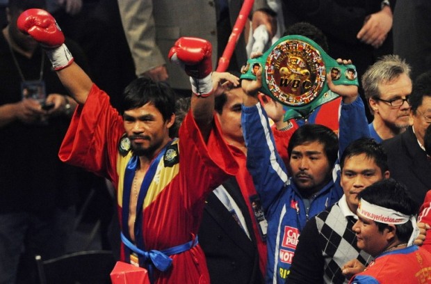Manny Pacquiao from the Philippines (L) salutes the crowd after defeating Joshua Clottey of Ghana during their WBO welterweight title fight at the Dallas Cowboys Stadium in Dallas, Texas on March 13, 2010. 