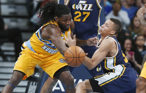 Denver Nuggets forward Kenneth Faried, left, vies for control of a loose ball with Utah Jazz guard Dante Exum during the third quarter of an NBA basketball game Friday, Feb. 27, 2015, in Denver. Utah won 104-82. (AP Photo/David Zalubowski)