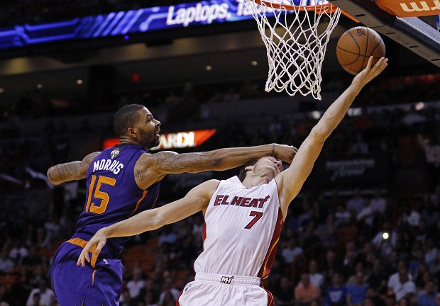 Miami Heat guard Goran Dragic (7) is fouled by Phoenix Suns forward Marcus Morris (15) during the first quarter of an NBA basketball game, Monday, March 2, 2015, in Miami. (AP Photo/Joe Skipper)