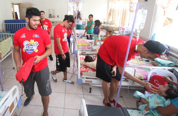 Reymond  Almazan (bottom right), Eric Camson (left), Terrence Romeo and Brian Heruela visits the childrens ward of Ospital ng Palawan. PBA Images/Nuki Sabio