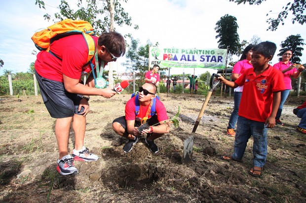 Beau Belga does an interview for TV5 on Paul Lee while planting a tree. PBA Images/Nuki Sabio