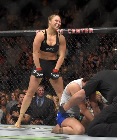 Ronda Rousey, top, celebrates as Cat Zingano kneels on the mat during a UFC 184 mixed martial arts bantamweight title bout, Saturday, Feb. 28, 2015, in Los Angeles. Rousey won after Zingano tapped out 14 seconds into the bout. (AP Photo/Mark J. Terrill)