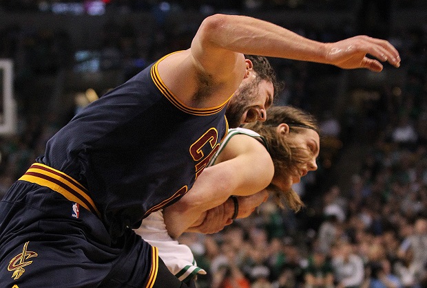Cleveland Cavaliers forward Kevin Love, left, yells with pain as he is dragged by the arm by Boston Celtics center Kelly Olynyk (41) during the first quarter of a first-round NBA playoff basketball game in Boston, Sunday, April 26, 2015. The play resulted in an injury to Love that forced him from the game. (Thomas Ondrey/The Plain Dealer via AP) MANDATORY CREDIT NO SALES
