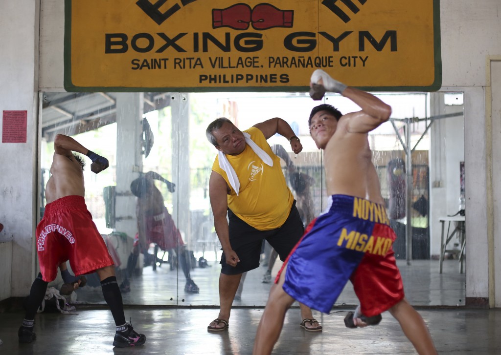 In this April 22, 2015, photo, Filipino boxing promoter and trainer Gabriel Elorde Jr., center, trains boxers at his boxing gym in suburban Paranaque, south of Manila, Philippines. Manny Pacquiao's rise from crushing poverty to global fame and fortune has inspired a whole generation of Filipino fighters, who look up to his legend as their dream and boxing as a ticket out of harsh lives and uncertainties. AP