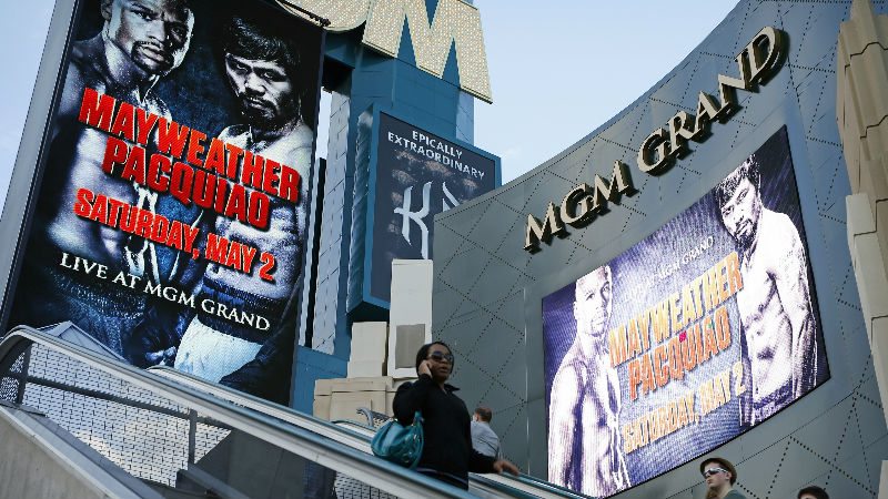 People ride an escalator by signs advertising the Mayweather Pacquiao fight at the MGM Grand Wednesday, April 22, 2015, in Las Vegas. (AP Photo/John Locher)