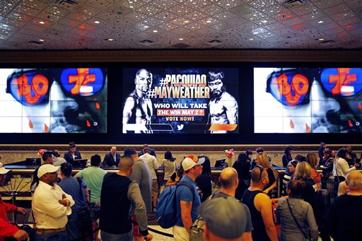 A screen shows an advertisement for a fight between Floyd Mayweather Jr. and Manny Pacquiao as people wait to check in at the MGM Grand on Friday  in Las Vegas. The fight is scheduled to take place May 2 at the hotel and casino. AP 