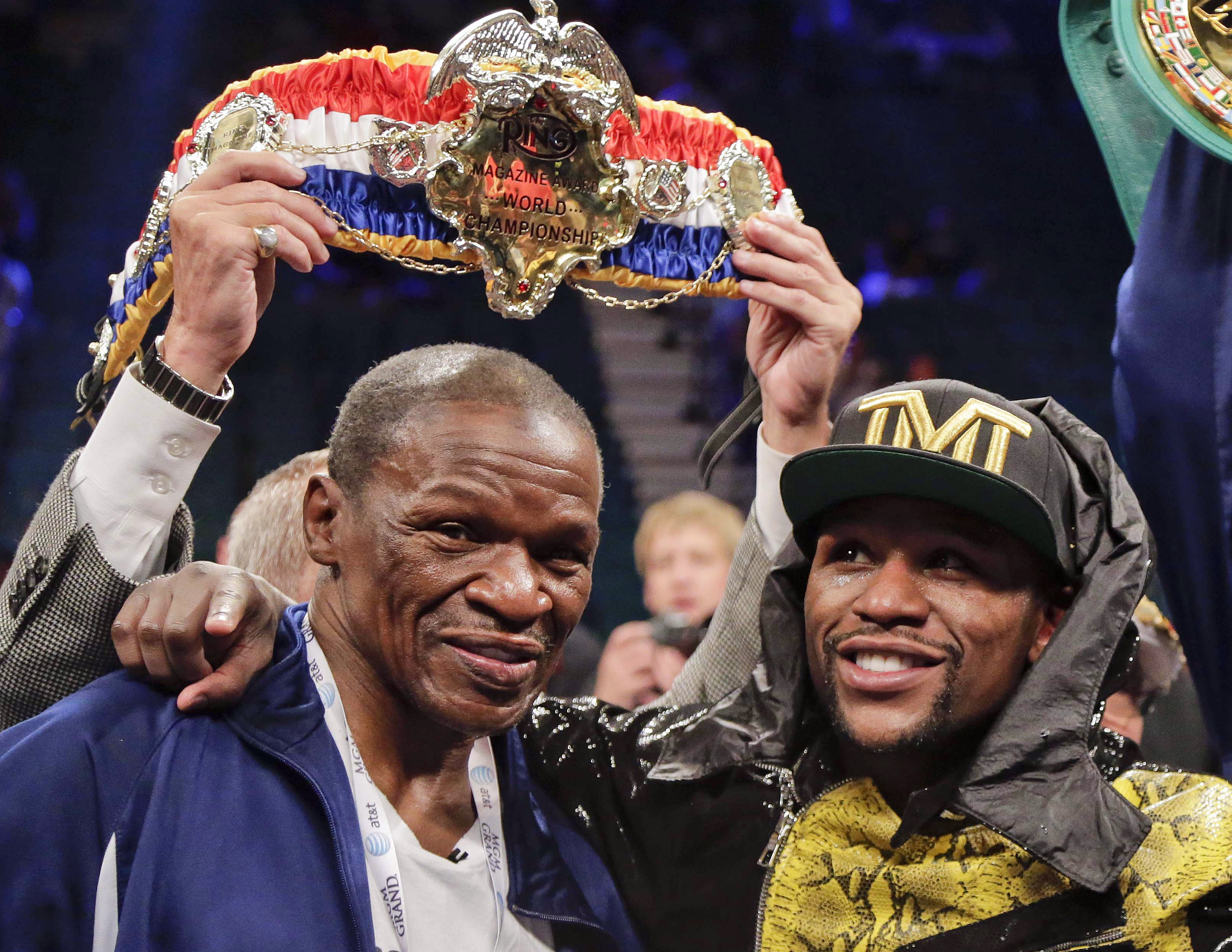 FILE - In this May 4, 2013, file photo, Floyd Mayweather Jr., right, poses for photos with his father, Floyd Mayeather Sr. after defeating Robert Guerrero by unanimous decision in a WBC welterweight title fight in Las Vegas. He taught his son to throw punches before he could walk, and he'll be in his corner for the biggest fight of his life against Manny Pacquiao on May 2. The relationship betwee Mayweather Sr. and his son, though, hasn't always been good. (AP Photo/Rick Bowmer, File)