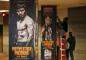 Workers install signs for an upcoming bout at the MGM Grand Garden Arena Monday, April 27, 2015, in Las Vegas. Floyd Mayweather Jr. and Manny Pacquiao are scheduled to fight May 2. (AP Photo/John Locher)