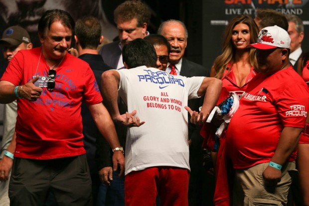 Manny Pacquiao shows his shirt with the phrase, "All glory and honor belongs to God" during his weigh in at the MGM Grand Arena in Las Vegas, Nevada. PHOTO BY REM ZAMORA