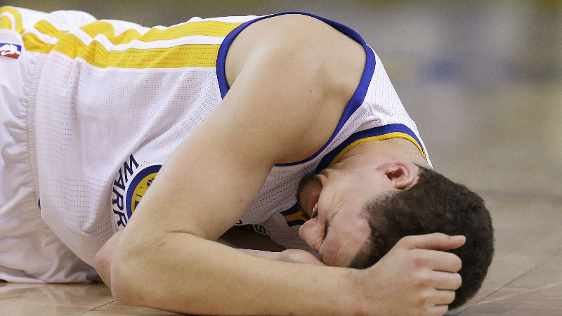 In this photo taken May 27, 2015, Golden State Warriors guard Klay Thompson reacts after taking a knee to his head from Houston Rockets forward Trevor Ariza during the second half of Game 5 of the NBA basketball Western Conference finals. The Warriors hope to get healthy and stay in tune over the next week before facing the Cleveland Cavaliers in the NBA Finals. Thompson needs to pass through the league's concussion protocol and Stepehen Curry is trying to get his aching body back at full strength. (AP Photo/Ben Margot)