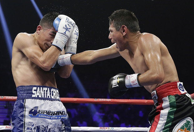 Jose Cayetano, right, of Mexico, lands a right to the body of Leo Santa Cruz, of Rosemead, Calif., during their featherweight fight on Saturday, May 2, 2015 in Las Vegas. (AP Photo/Isaac Brekken)