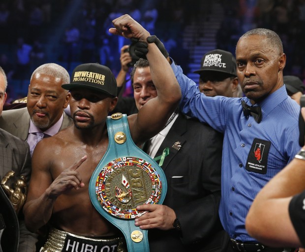 Floyd Mayweather Jr., left, holds up the title belt next to referee Kenny Bayless after his win against Manny Pacquiao, from the Philippines, in their welterweight title fight on Saturday, May 2, 2015 in Las Vegas. (AP Photo/John Locher)
