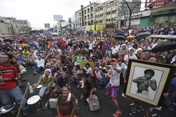 Filipinos watch a live satellite feed of the welterweight title fight between Filipino boxing hero Manny Pacquiao and Floyd Mayweather Jr. during a free public viewing in downtown Manila, Philippines on Sunday, May 3, 2015. Mayweather Jr. won the match. (AP Photo/Aaron Favila)
