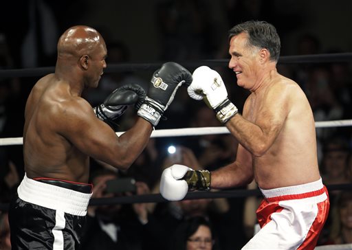 Former Republican presidential candidate Mitt Romney, right, throws punches with five-time heavyweight boxing champion Evander Holyfield at a charity fight night event Friday, May 15, 2015, in Salt Lake City.  AP