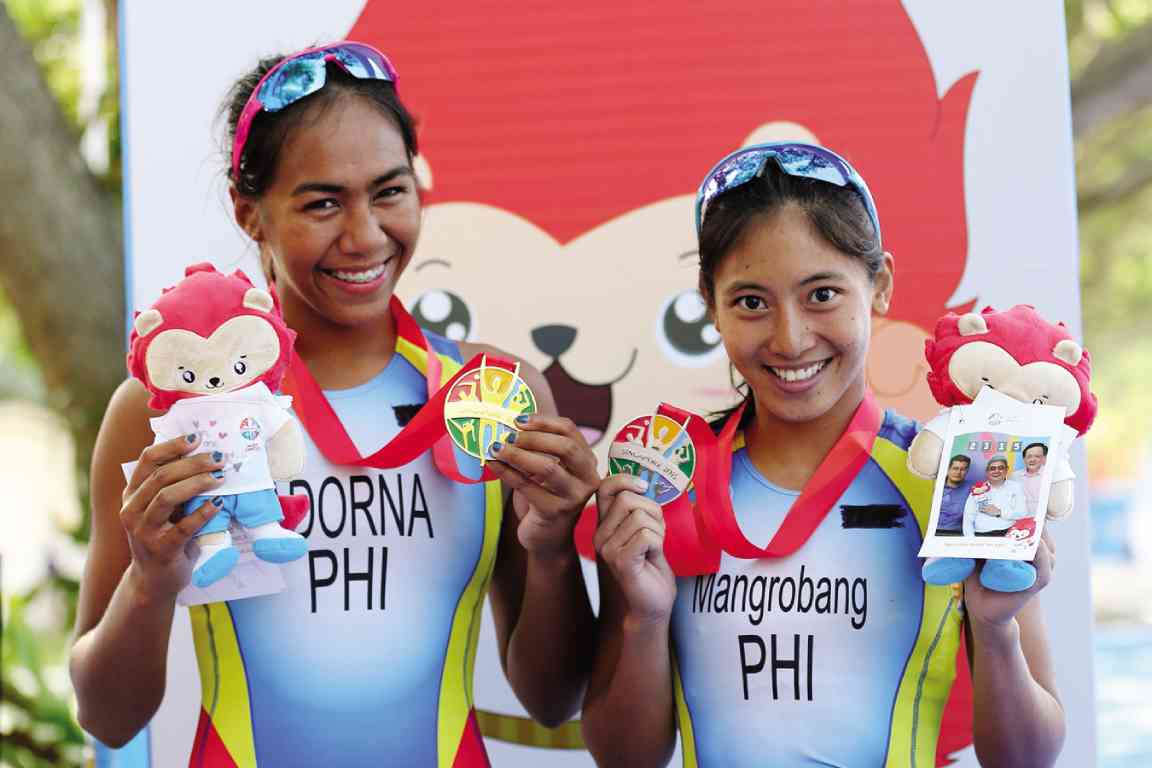  Lighting up the faces of the Philippines’ Claire Adorna and Kim Mangrobang are their smiles and their gold and silver medals, respectively, in the women’s triathlon on Saturday. RAFFY LERMA 