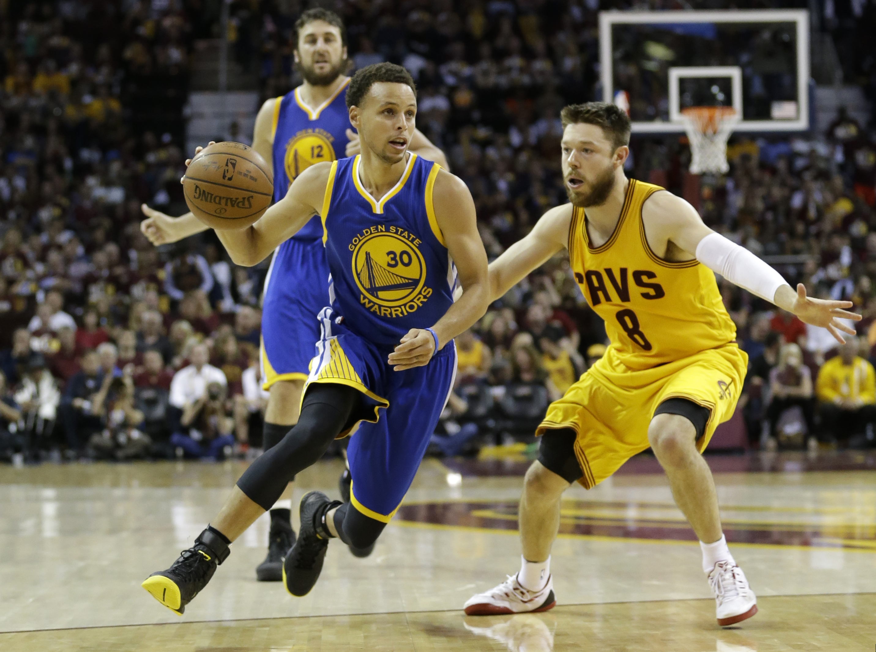 Golden State Warriors guard Stephen Curry (30) drives on Cleveland Cavaliers guard Matthew Dellavedova (8) during the second half of Game 3 of basketball's NBA Finals in Cleveland, Tuesday, June 9, 2015. (AP Photo/Tony Dejak)