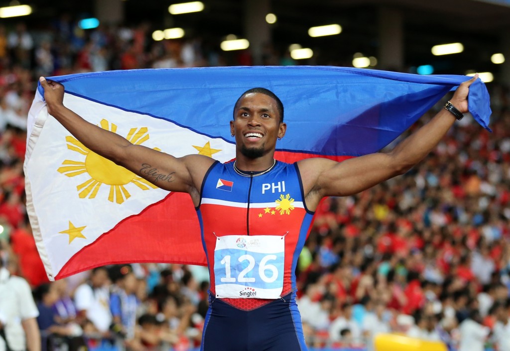 Eric Shauwn Cray of the Philippines carries the flag after his gold medal at the 28th SEA Games Men's 100m finals held at the National Stadium, Singapore Sports Hub. INQUIRER PHOTO/RAFFY LERMA