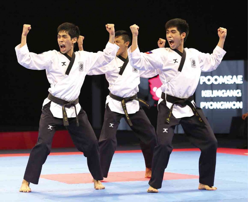 THE PHILIPPINES’ Dustin Jacob Mella, Rodolfo Reyes Jr. and Raphael Enrico Mella (from left) execute their gold-medal routine in Friday’s men’s poomsae team competition in taekwondo at the 28th SEA Games in Singapore. RAFFY LERMA 