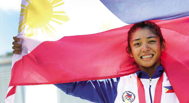 CYCLIST Marella Vania Salamat holds up the flag after winning a gold medal.  RAFFY LERMA