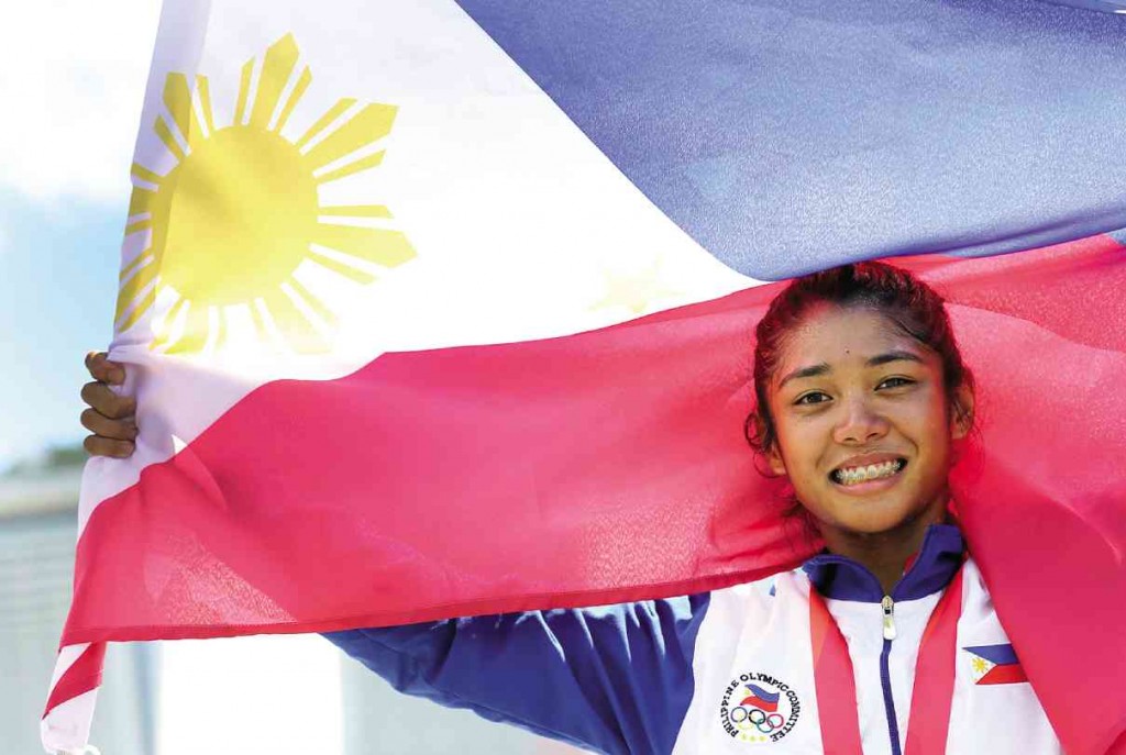 CYCLIST Marella Vania Salamat holds up the flag after winning a gold medal.  RAFFY LERMA
