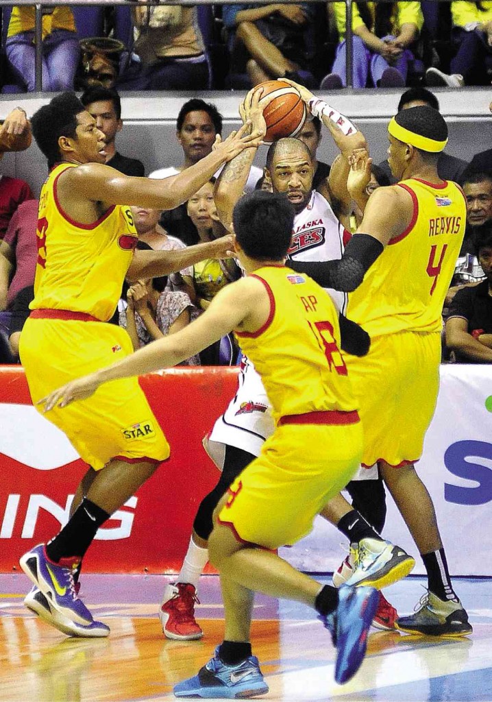 RELENTLESS Alaska reinforcement Romeo Travis tries to twist about and wriggle free of a Star triple team of (from left) Joe Devance, James Yap and Rafi Reavis in last night’s Game 3 at the Big Dome. AUGUST DELA CRUZ 