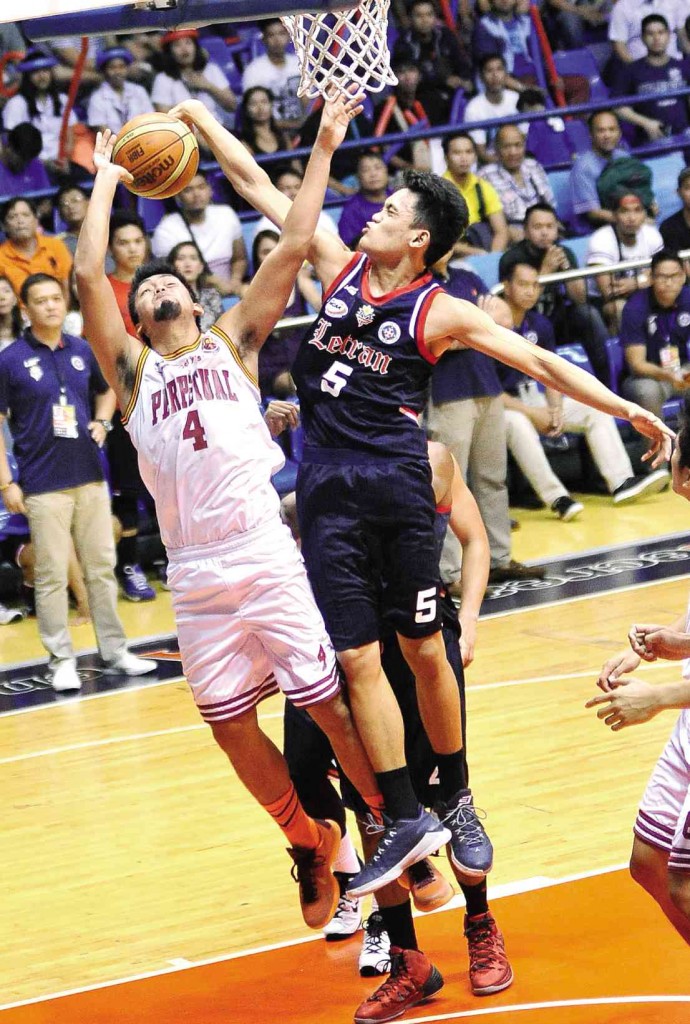 LETRAN’S Jomari Sollano blocks a driving Kevin Oliveria of Perpetual Help in yesterday’s game at Filoil Flying V Arena. AUGUST DELA CRUZ 