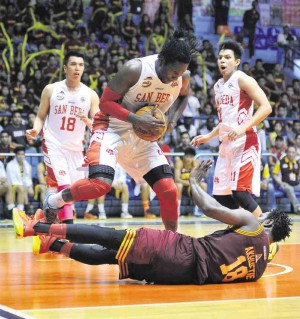 SAN Beda slotman Ola Adeogun tries to avoid a fallen Bright Akhueti after the Perpetual Help center slipped during a rebound scramble in yesterday’s game at Filoil Flying V Arena in San Juan. AUGUST DELA CRUZ 