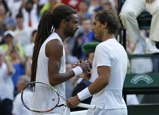 Dustin Brown of Germany, left, shakes hands at the net with Rafael Nadal of Spain, after defeating him during the singles match, at the All England Lawn Tennis Championships in Wimbledon, London, Thursday July 2, 2015. AP PHOTO