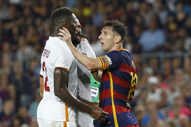 AS Roma's French defender Mapou Yanga-Mbiwa (L) is touched by Barcelona's Argentinian forward Lionel Messi (R) during the 50th Joan Gamper Trophy football match FC Barcelona vs AS Roma at the Camp Nou stadium in Barcelona on August 5, 2015.  AFP PHOTO / QUIQUE GARCIA