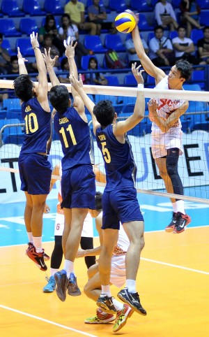 EAC’s Howard Mojica attacks the NU wall put up by Ysmail Fauzi (10), Francis Saura (11) and Eldrige Capal in yesterday’s game. AUGUST DELACRUZ