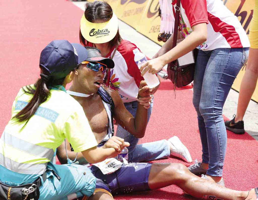Medics attend to Filipino male Elite winner August Benedicto who collapses after crossing the finish line at Mactan Shangri-la of the Ironman 70.3 Philippines. MARIANNE BERMUDEZ