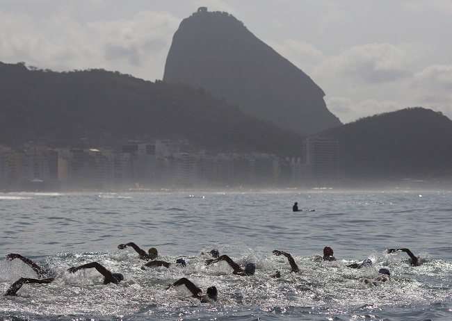 In this Aug. 22, 2015 file photo, backdropped by Sugar Loaf Mountain, athletes compete in the men's marathon swimming test event, ahead of the Rio 2016 Olympic Games, off Copacabana Beach, Rio de Janeiro, Brazil. AP