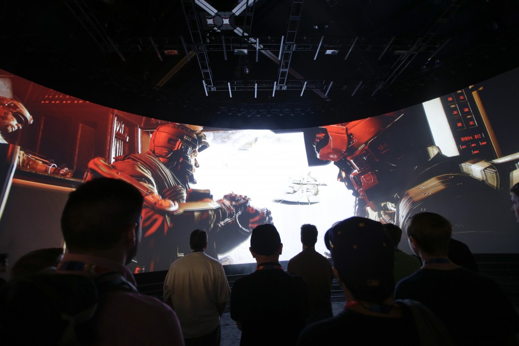 FILE - In this June 12, 2014 file photo, people watch the "Call of Duty: Advanced Warfare" video game trailer at the Activision booth at the Electronic Entertainment Expo, in Los Angeles. (AP Photo/Jae C. Hong, File)