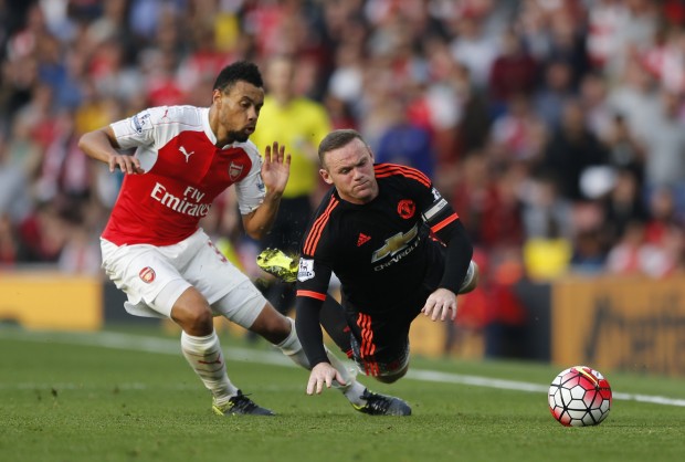 Manchester United's Wayne Rooney, right falls after a challenge by Arsenal's Francis Coquelin during the English Premier League soccer match between Arsenal and Manchester United at Emirates stadium in London, Sunday, Oct. 4, 2015.(AP Photo/Frank Augstein)