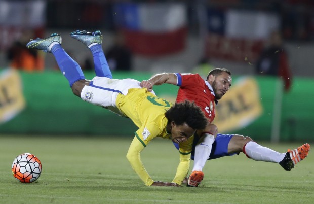Brazil's Willian, left, is taken down by Chile's Marcelo Diaz during a 2018 Russia World Cup qualifying soccer match in Santiago, Chile, Thursday, Oct. 8, 2015. (AP Photo/Martin Mejia)