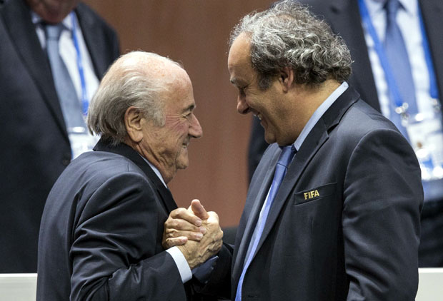 In this May 29, 2015 file photo, FIFA president Sepp Blatter after his election as President, left, is greeted by UEFA President Michel Platini, right, at the Hallenstadion in Zurich, Switzerland. AP