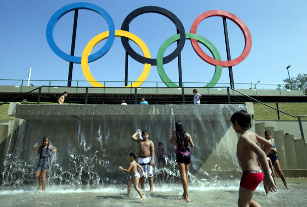 In this July 28, 2015 file photo, children play in a water fountain next to Olympic rings at Madureira Park in Rio de Janeiro, Brazil. AP