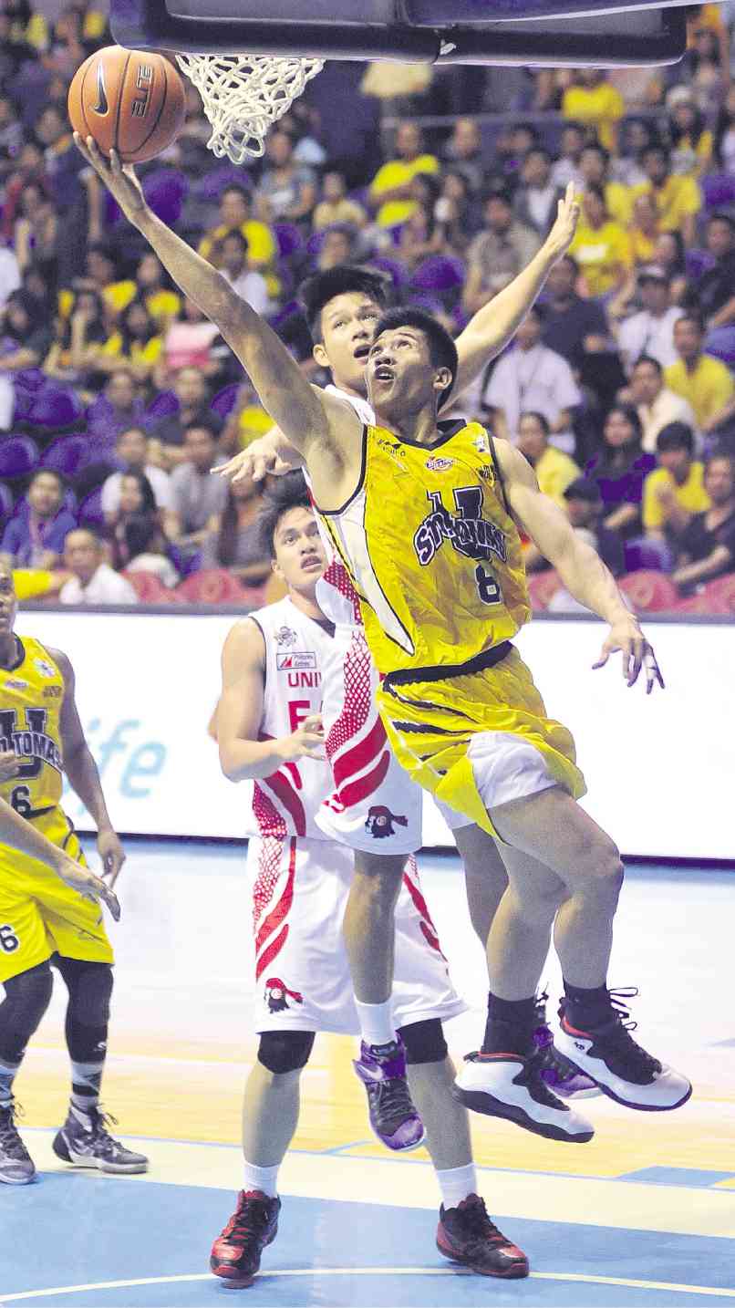 RISING Tigers star Ed Daquioag (front) rips the defense of Clark Derige of UE with an undergoal stab en route to a season-high 34 points.  AUGUST DELA CRUZ