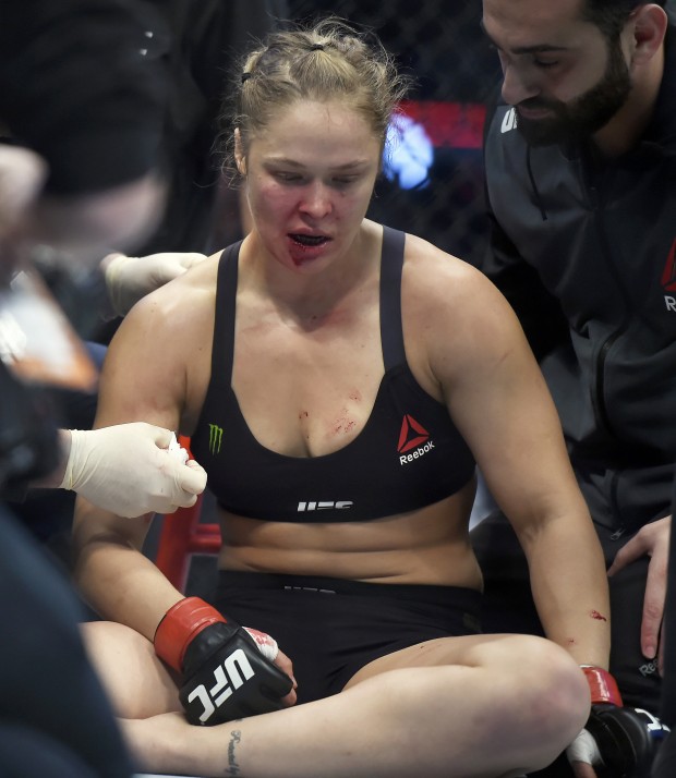 Ronda Rousey is treated by a medical staff member after being knocked out by Holly Holm in their UFC 193 bantamweight title fight in Melbourne, Australia, Sunday, Nov. 15, 2015. Holm pulled off a stunning upset victory over Rousey in the fight, knocking out the women's bantamweight champion in the second round with a powerful kick to the head Sunday.  (AP Photo/Andy Brownbill)