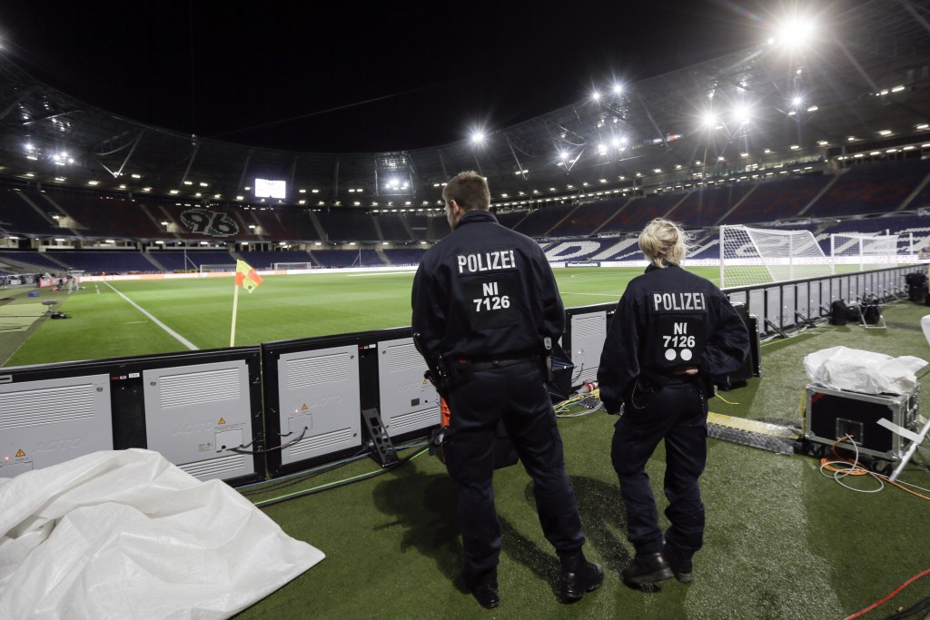 Two police officers stand in the stadium in Hannover, Germany, early Wednesday, Nov. 18, 2015, after friendly soccer game between Germany and the Netherlands was canceled 90 minutes before kickoff on Tuesday due to the suspected threat of a bomb at the stadium. (AP Photo/Markus Schreiber)