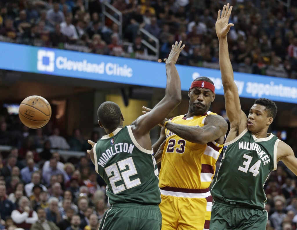 Cleveland Cavaliers' LeBron James (23) passes around Milwaukee Bucks' Giannis Antetokounmpo (34), from Greece, and Khris Middleton (22) in the first half of an NBA basketball game Thursday, Nov. 19, 2015, in Cleveland. AP