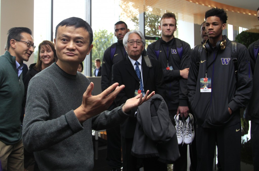  Jack Ma, left, executive chairman of the Alibaba Group, left, gestures while standing with players from the University of Washington men's basketball team in Hangzhou in eastern China's Zhejiang province Tuesday, Nov. 10, 2015. AP