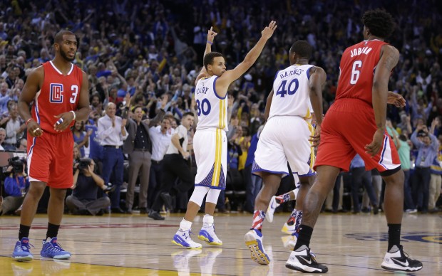 Golden State Warriors' Stephen Curry (30) celebrates a score against the Los Angeles Clippers during the second half of an NBA basketball game Wednesday, Nov. 4, 2015, in Oakland, Calif. At left is Clippers' Chris Paul (3). The Warriors won 112-108. (AP Photo/Ben Margot)