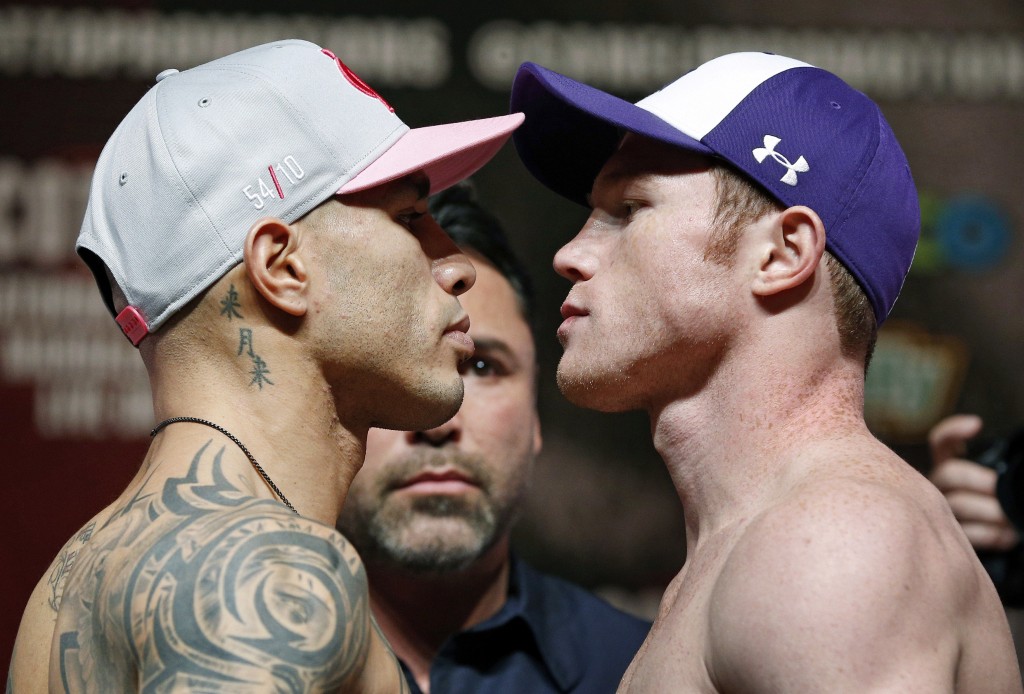 Miguel Cotto, of Puerto Rico, left, and Canelo Alvarez, of Mexico, pose for photographers during a weigh-in Friday, Nov. 20, 2015, in Las Vegas. The two are scheduled to fight in a WBC middleweight title bout Saturday in Las Vegas.(AP Photo/John Locher)