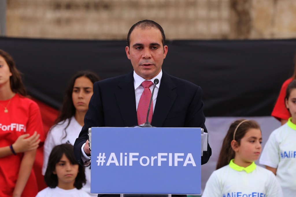 In this file photo dated Wednesday, Sept. 9, 2015, Jordan's Prince Ali bin al-Hussein, flanked by school-age soccer players, speaks to about 300 guests during an event at a Roman amphitheater in Amman, Jordan. AP